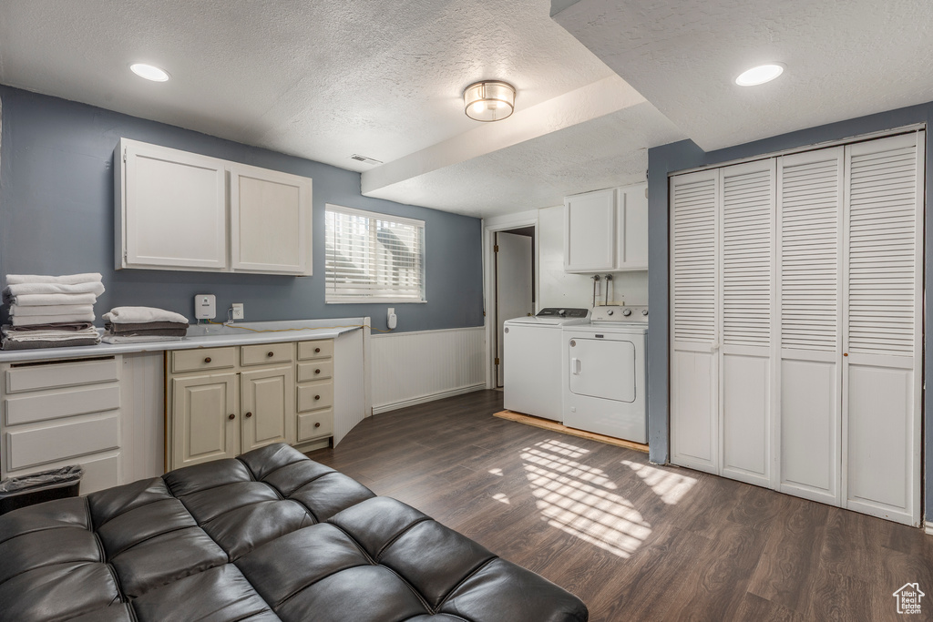 Kitchen with washer and dryer, a textured ceiling, dark wood-style floors, light countertops, and recessed lighting