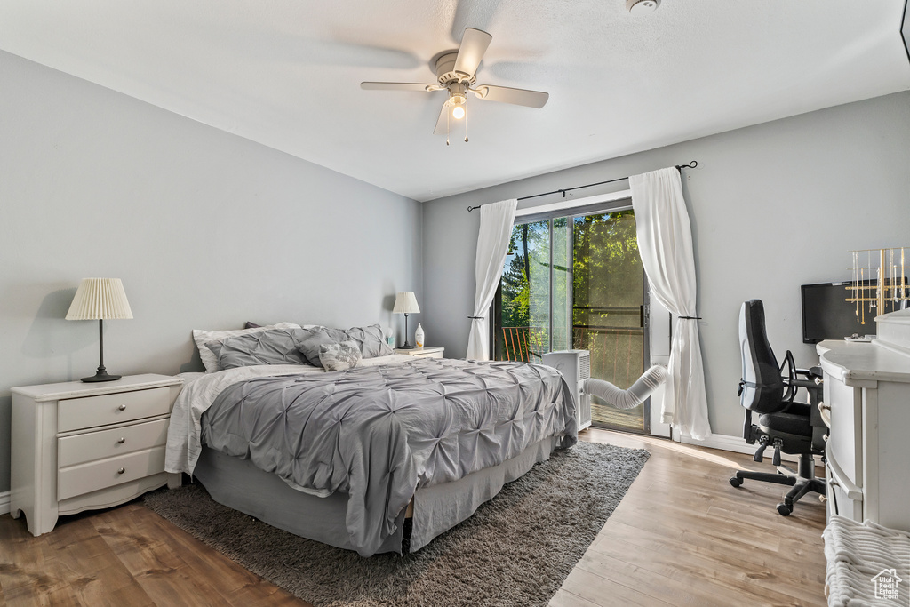 Bedroom featuring access to outside, wood finished floors, an office area, and ceiling fan