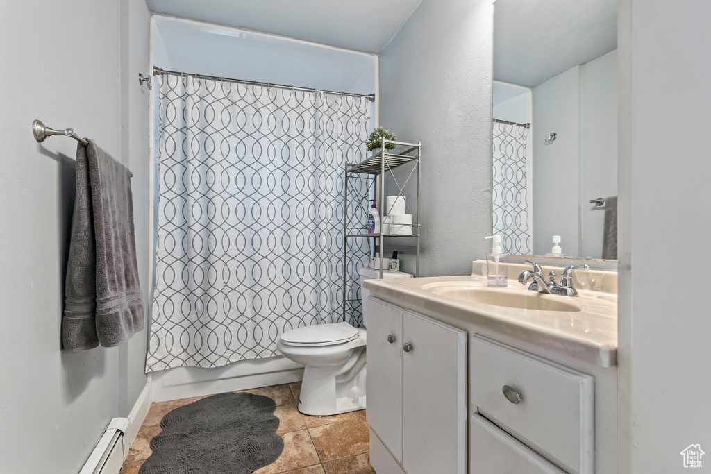 Full bath featuring vanity, a baseboard heating unit, and a textured wall
