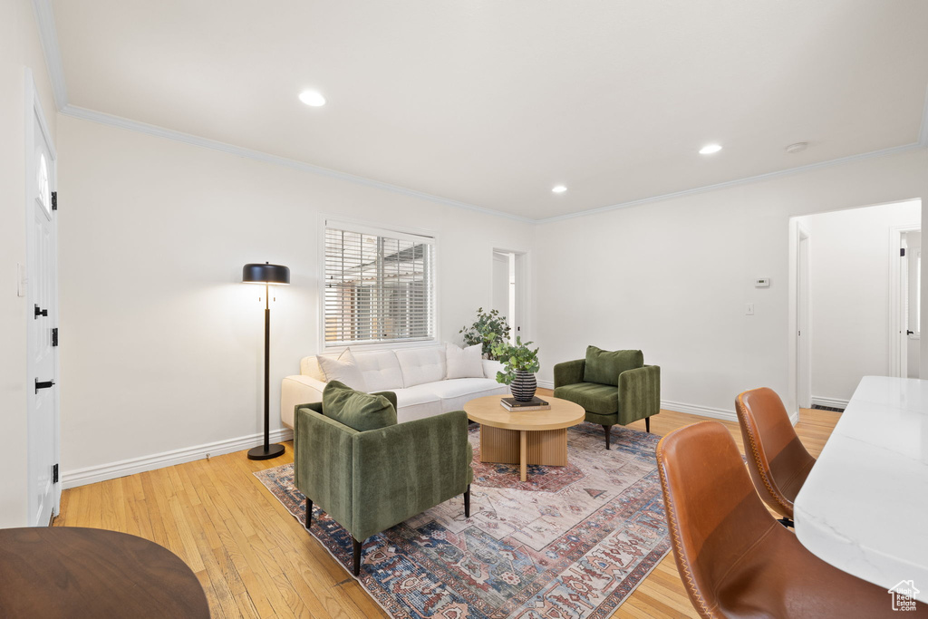 Living area with crown molding, light wood finished floors, and recessed lighting