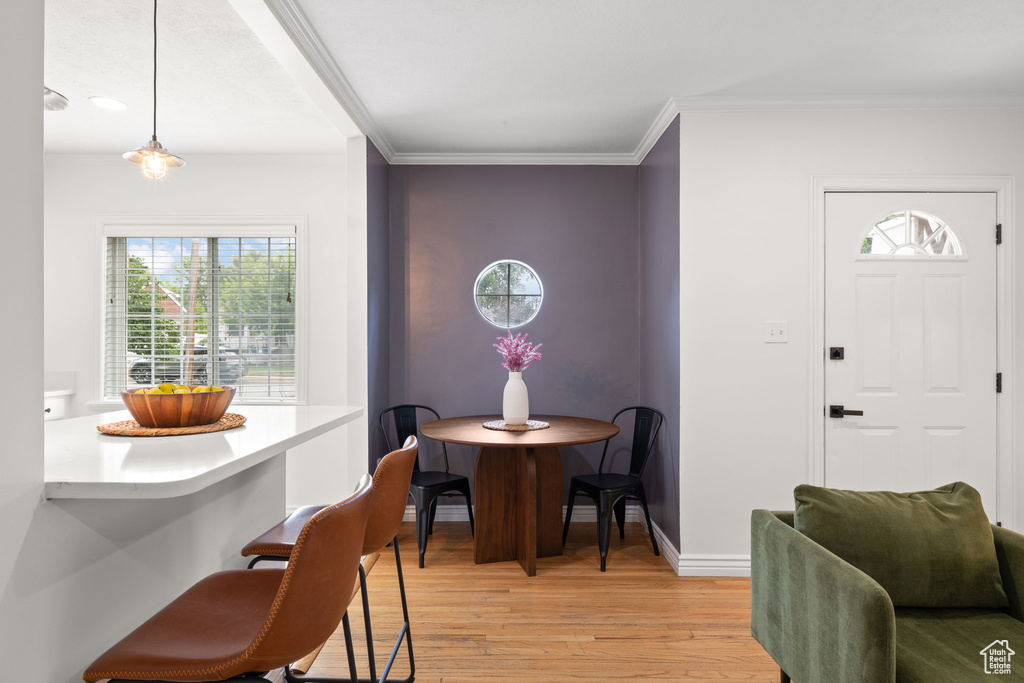 Dining area featuring light wood-type flooring and crown molding