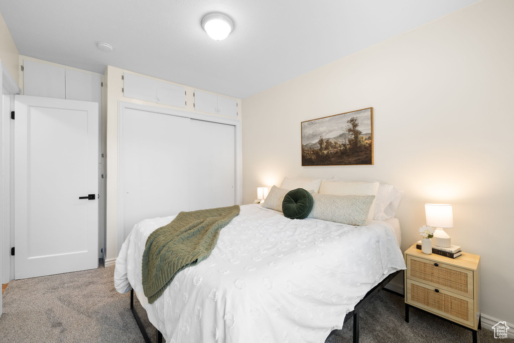 Carpeted bedroom with a closet and baseboards