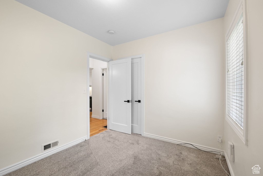 Unfurnished bedroom featuring carpet and multiple windows