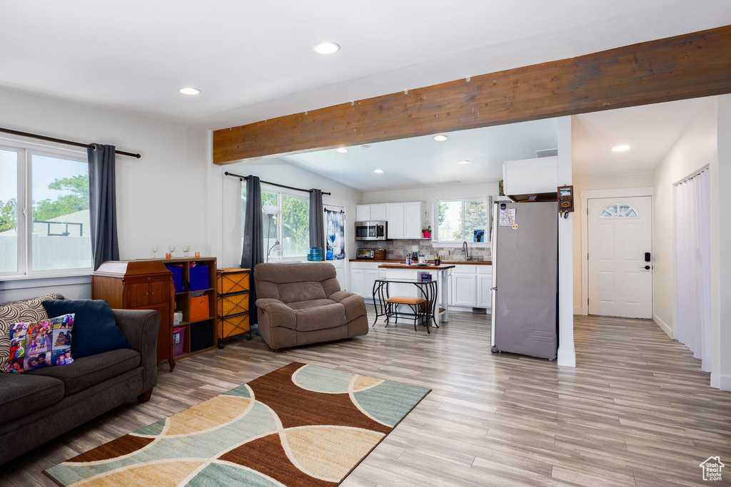 Living area with recessed lighting and light wood-style flooring