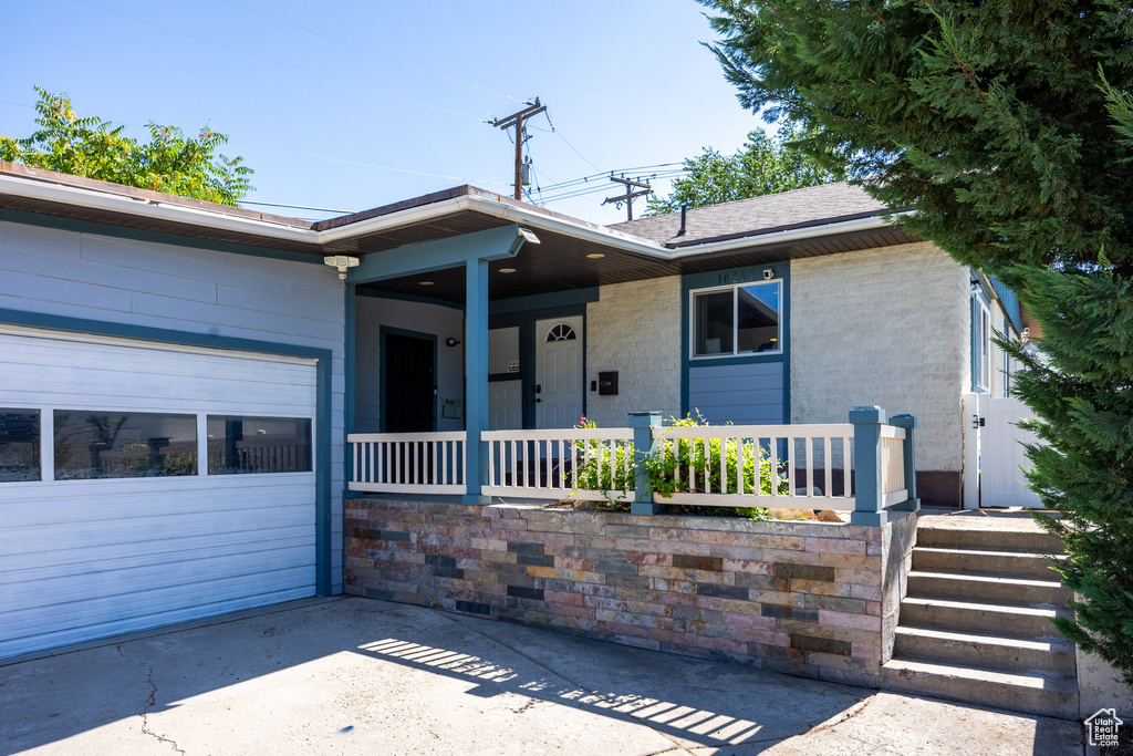 Ranch-style house featuring covered porch and a garage