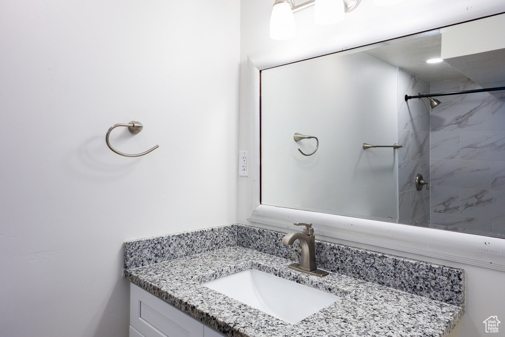 Bathroom with vanity and tiled shower