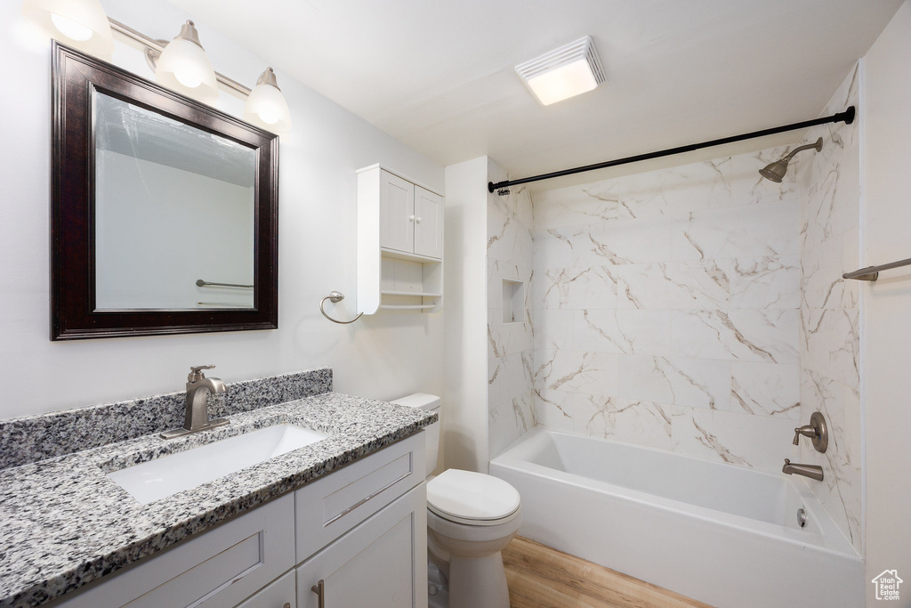Full bath with vanity, shower / bath combination, and wood finished floors