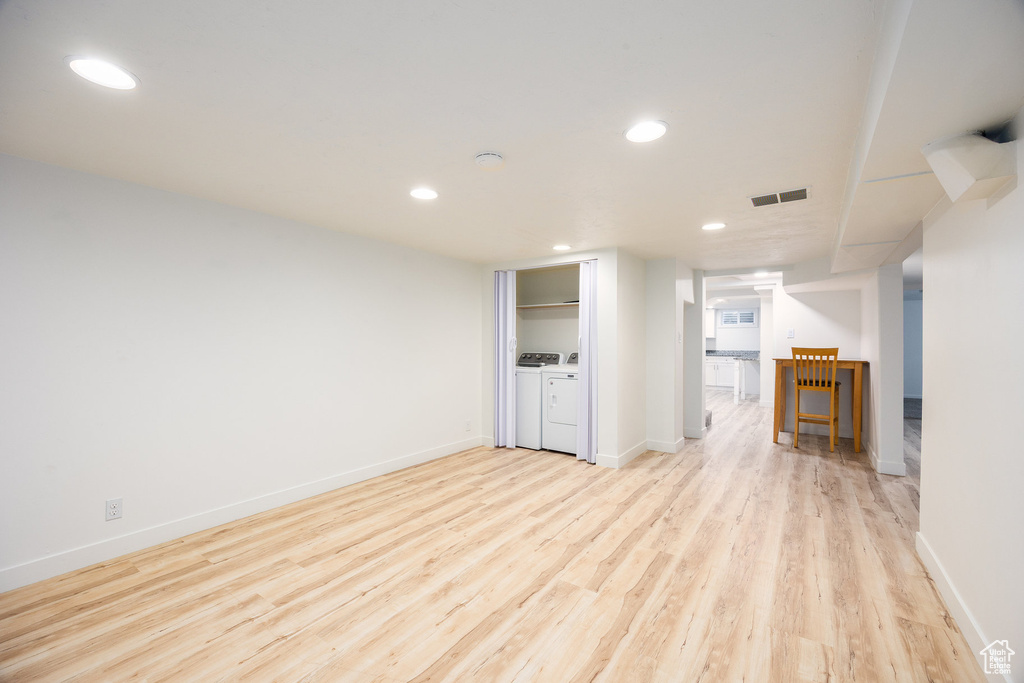 Unfurnished living room featuring light wood-style flooring, recessed lighting, and washer and clothes dryer