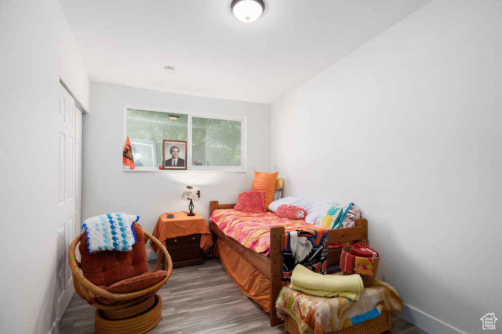Bedroom with wood finished floors and a closet