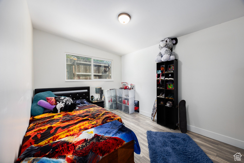 Bedroom featuring lofted ceiling and wood finished floors