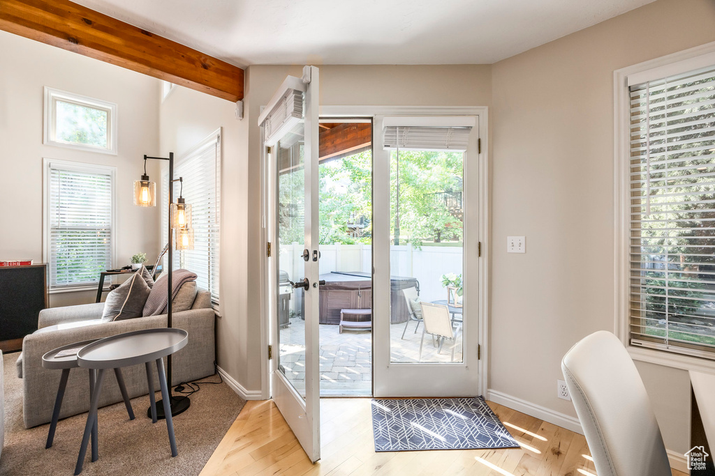 Doorway to outside featuring light wood-type flooring, french doors, and beam ceiling