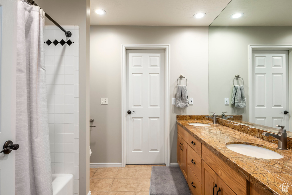 Bathroom with double vanity, shower / tub combo, recessed lighting, and tile patterned flooring