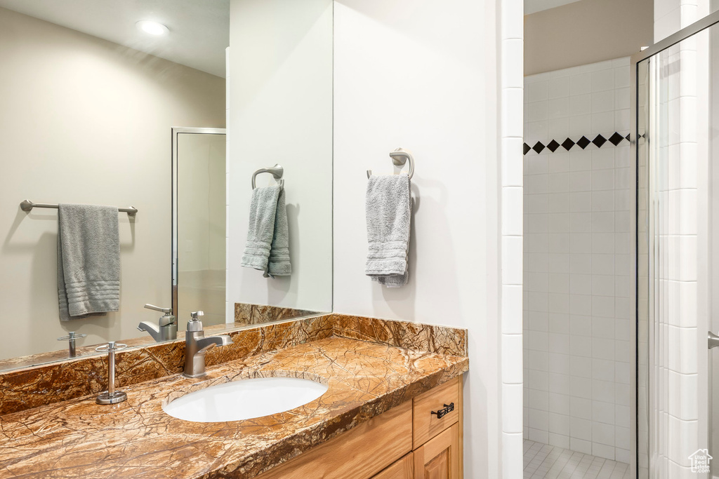 Bathroom featuring a stall shower, vanity, and recessed lighting