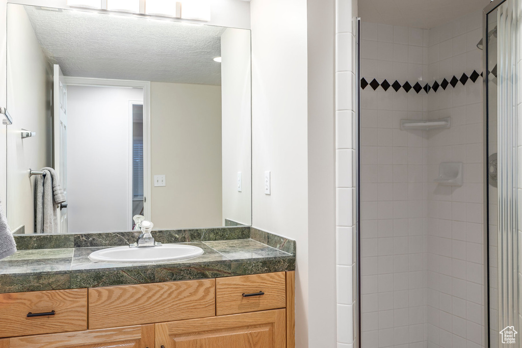 Bathroom featuring vanity and a shower stall
