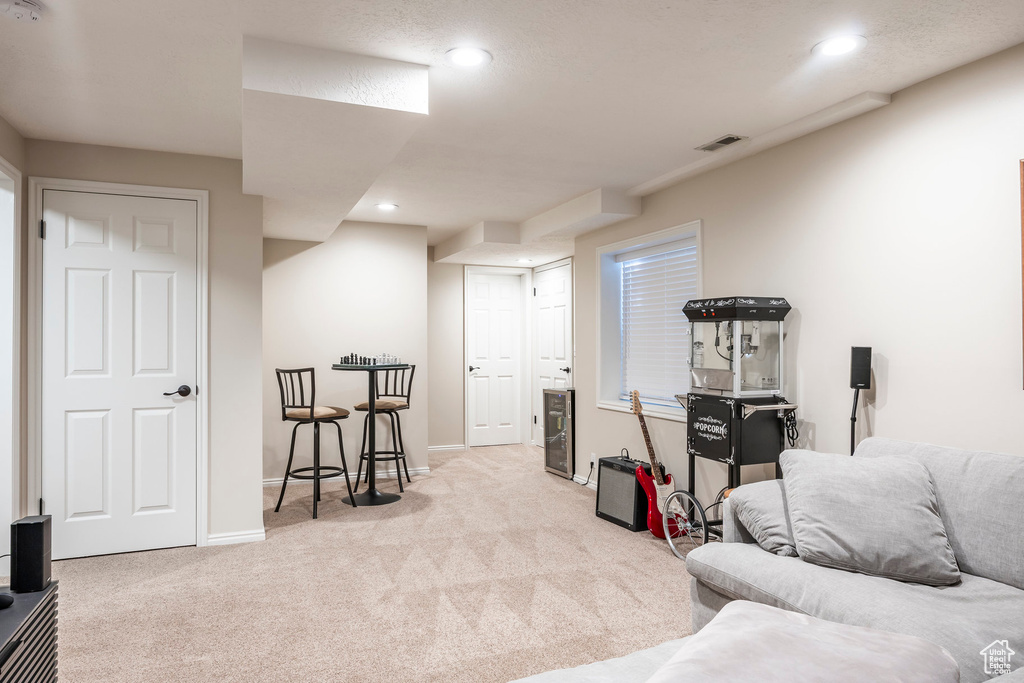 Sitting room with carpet floors, recessed lighting, and beverage cooler