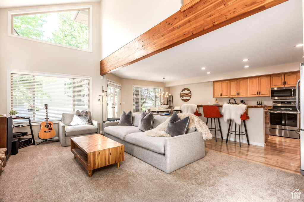 Living area with recessed lighting, light colored carpet, light wood finished floors, and bar area