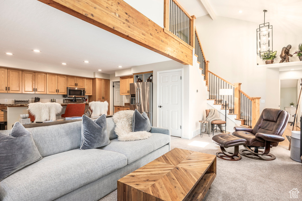Living area with recessed lighting, light carpet, beam ceiling, stairs, and high vaulted ceiling