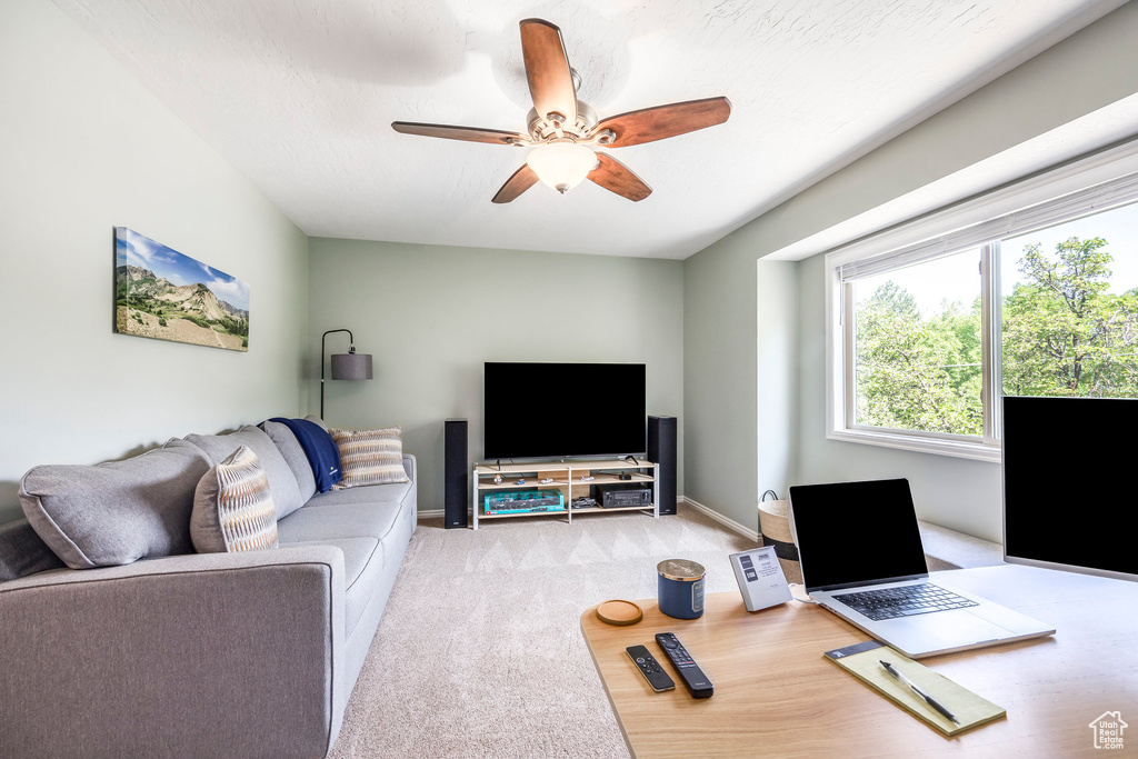 Living room with ceiling fan, carpet flooring, and an office area