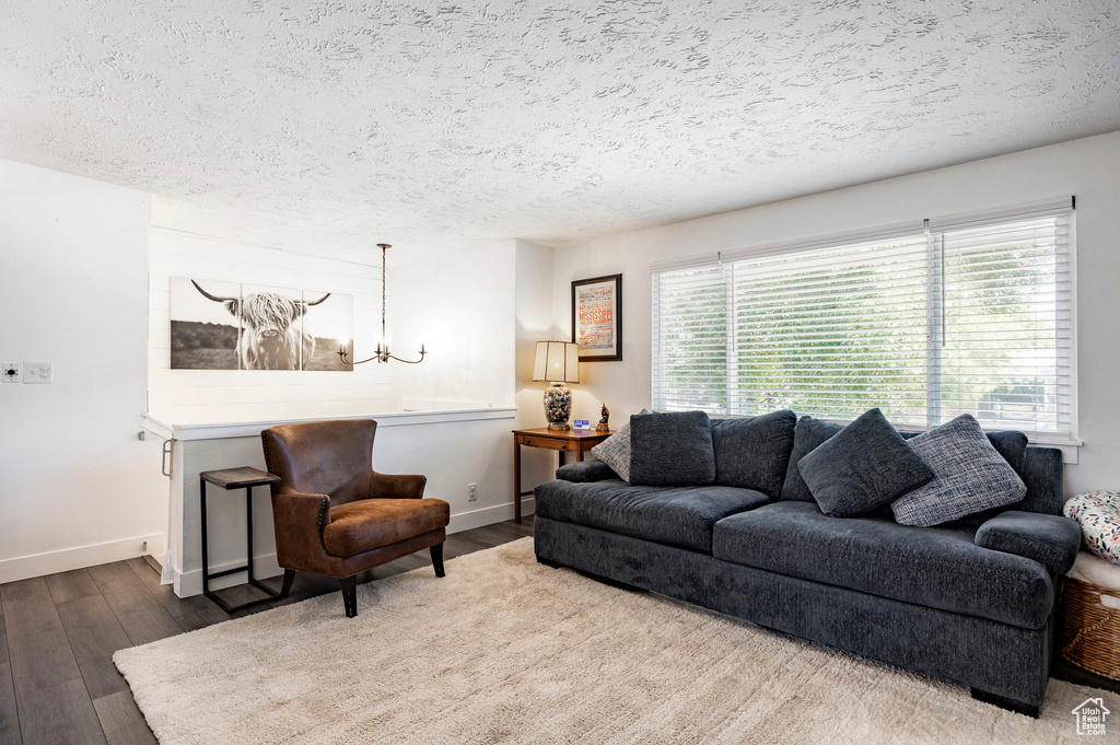 Living area featuring wood finished floors, a textured ceiling, and a chandelier