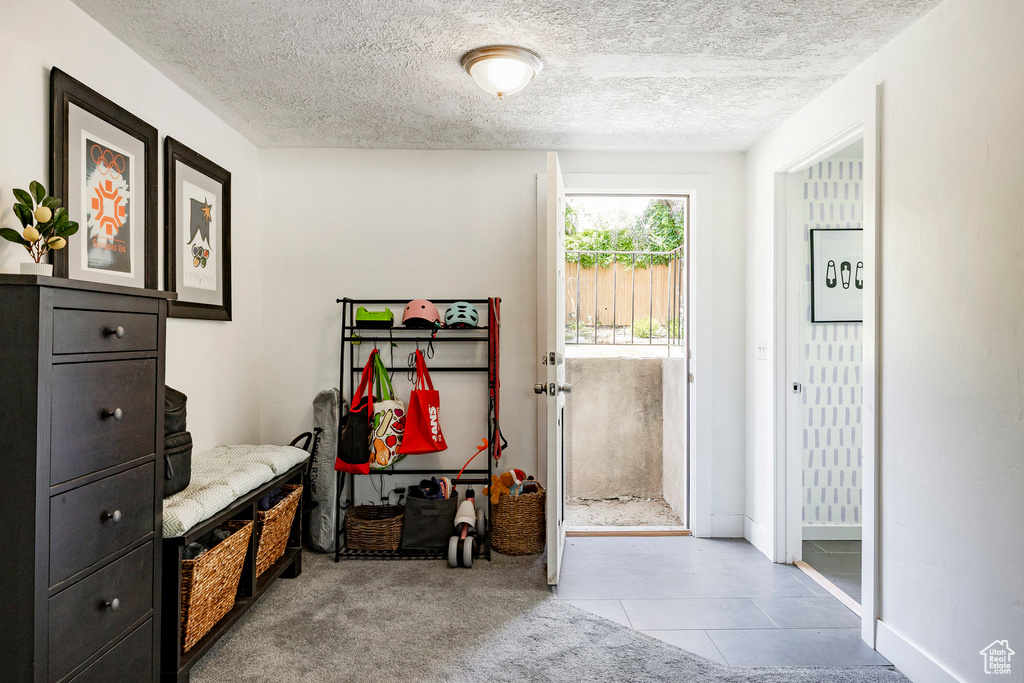 Mudroom with a textured ceiling and tile patterned flooring