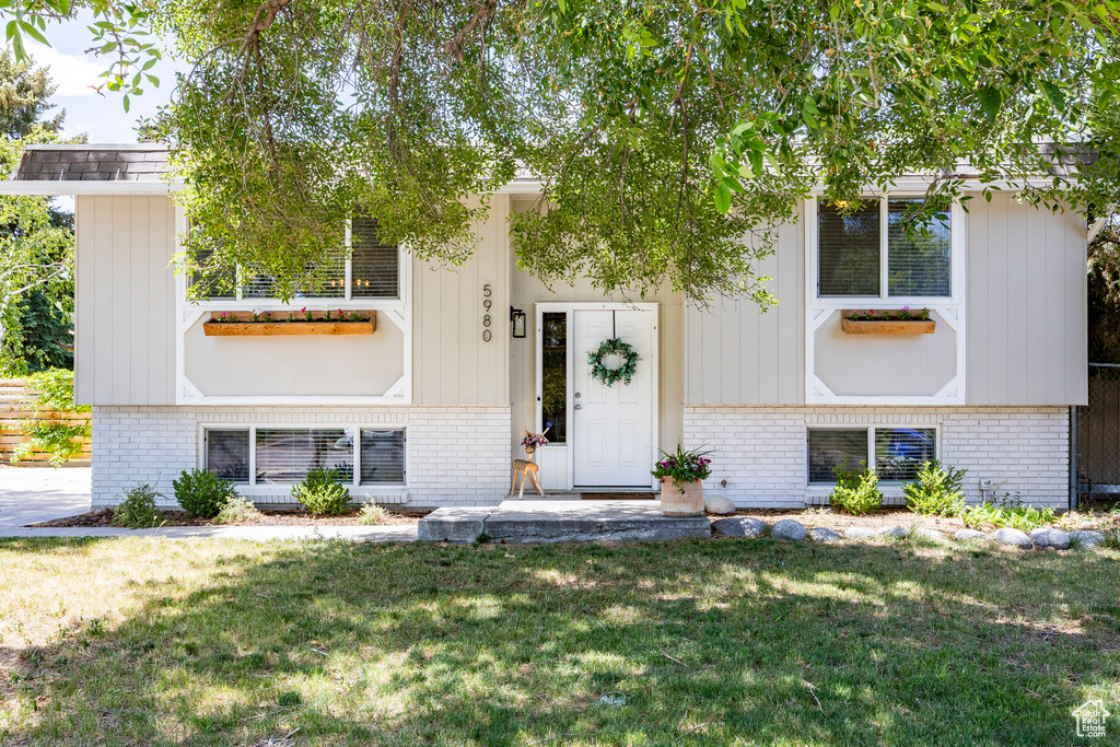 View of front of property with brick siding and a front yard