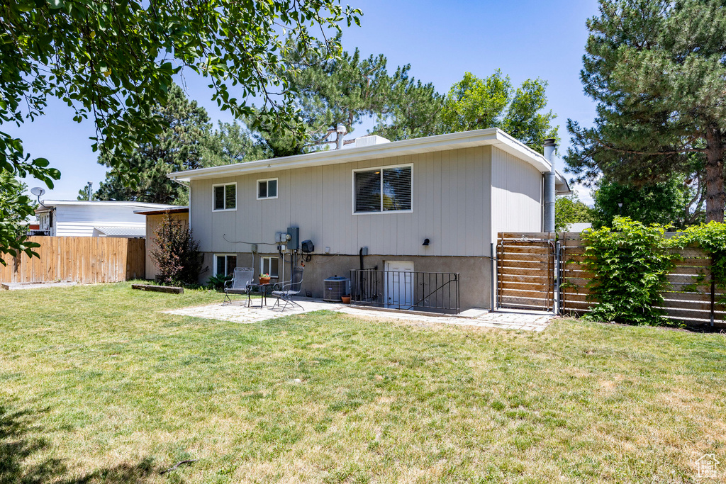 Back of house featuring a fenced backyard, a patio, and a gate