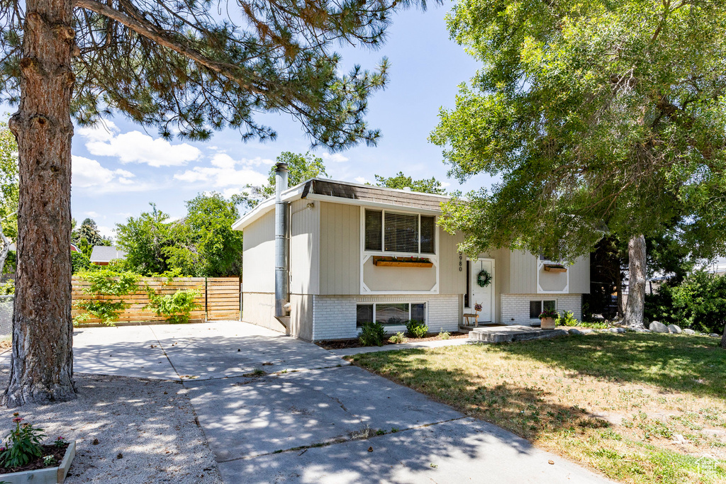 Split foyer home with brick siding and driveway