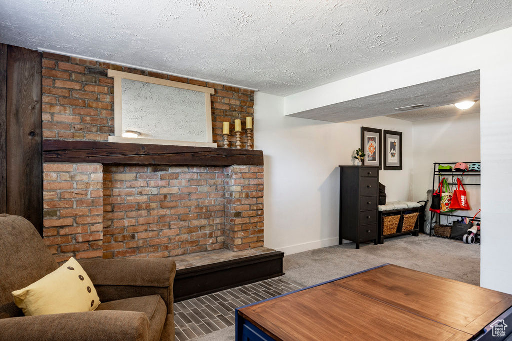Carpeted living room featuring a textured ceiling and baseboards