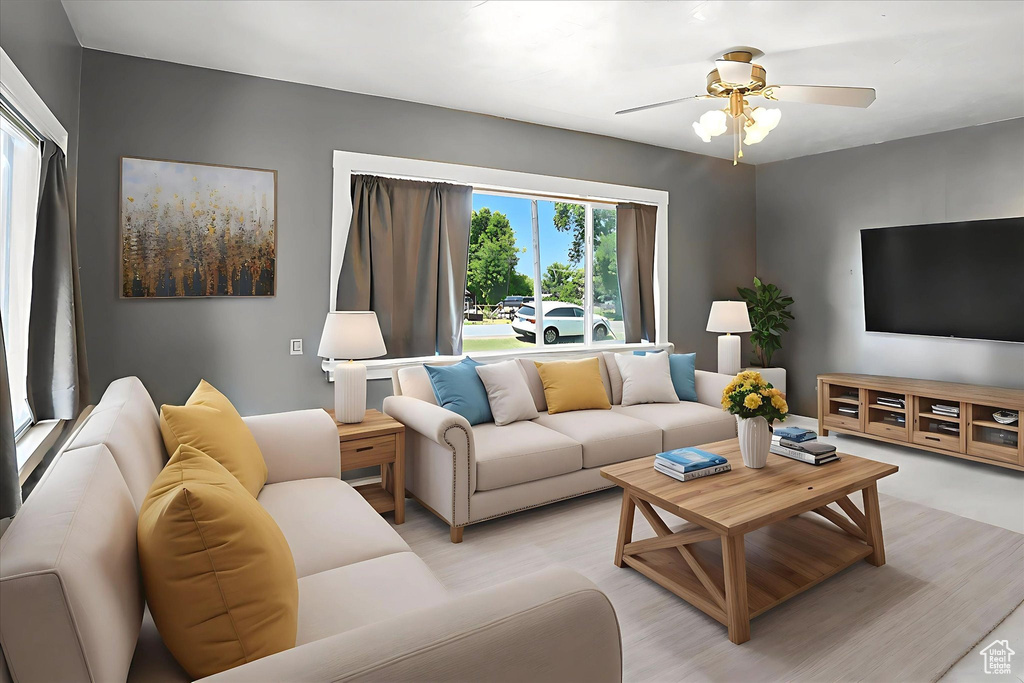 Living area with a ceiling fan and light wood finished floors