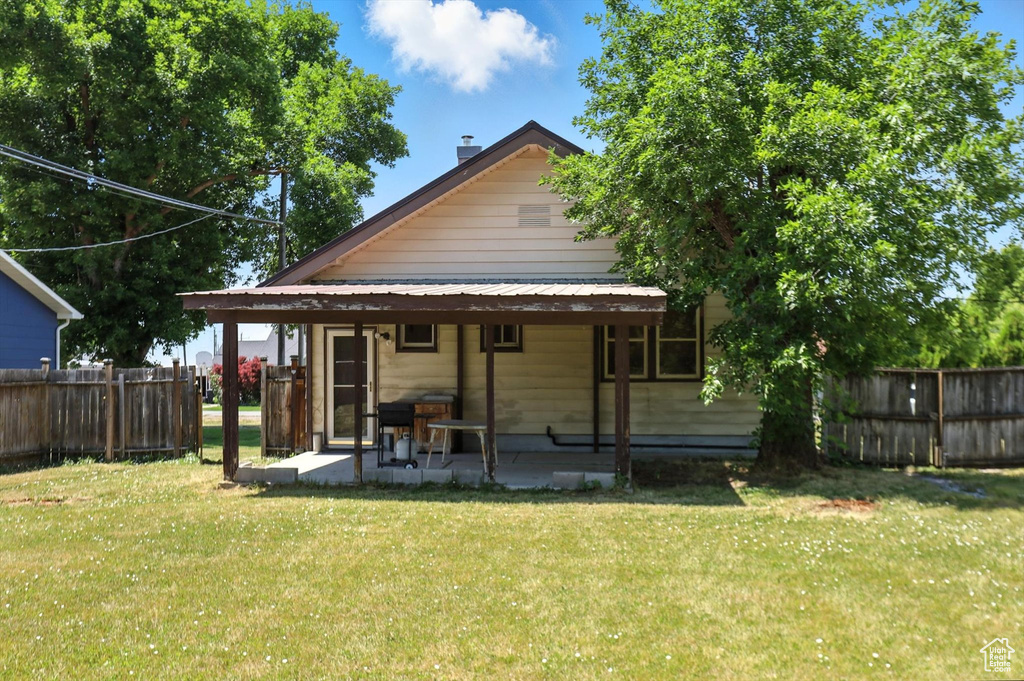 Rear view of house with a chimney and a patio area