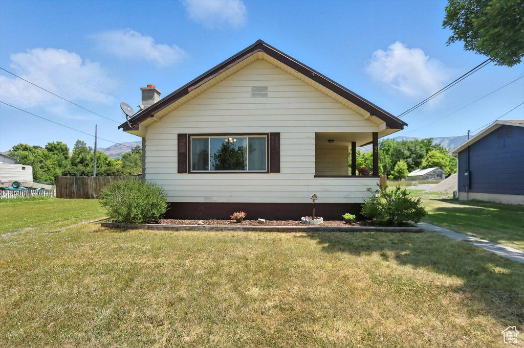 View of front of house with a chimney and covered porch
