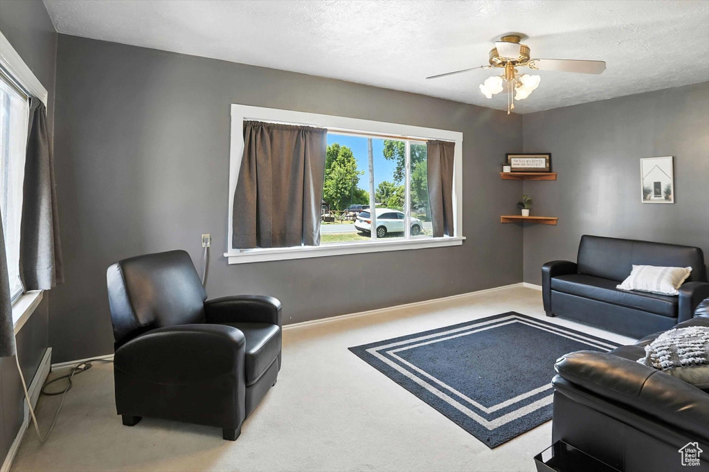 Living room with carpet floors, a textured ceiling, and ceiling fan