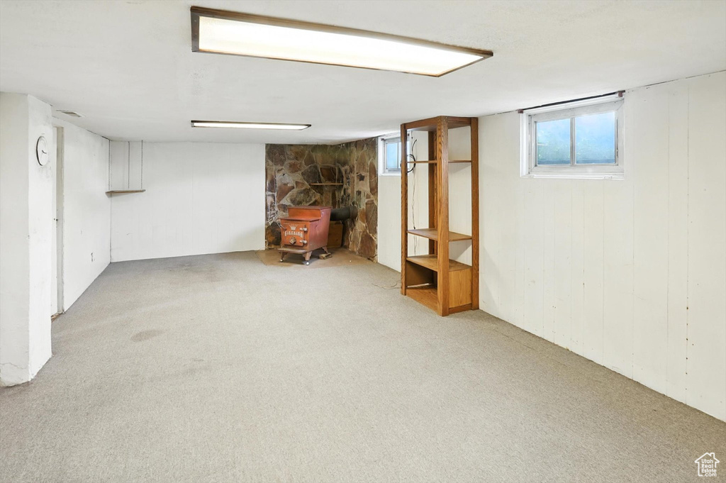 Basement featuring a wood stove and carpet