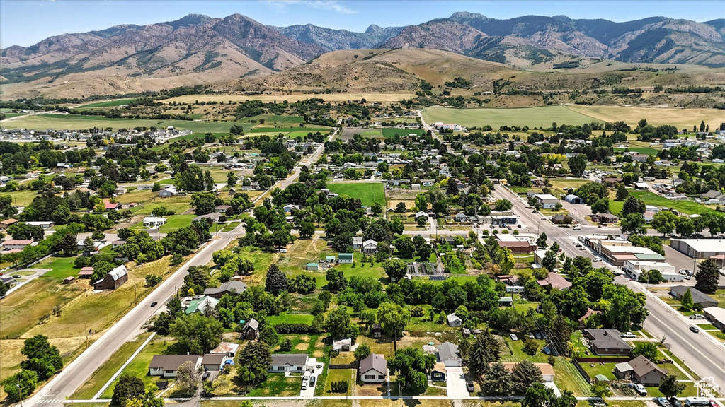 Aerial view of property and surrounding area with a mountainous background and nearby suburban area