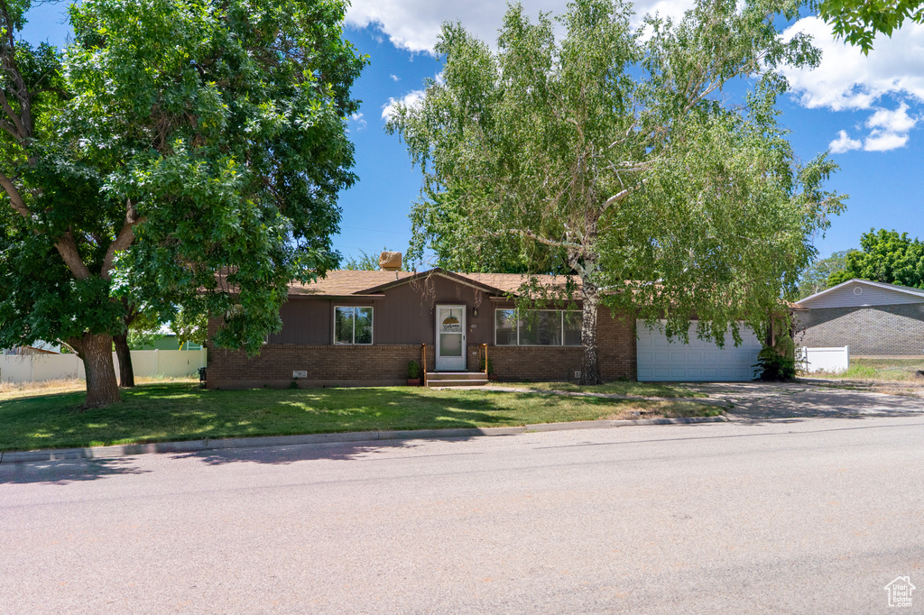 View of front of home with brick siding, driveway, entry steps, a chimney, and a garage