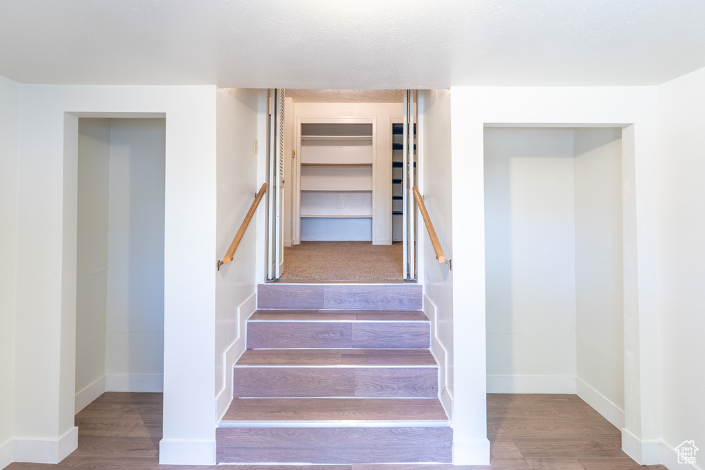 Staircase with wood finished floors and baseboards