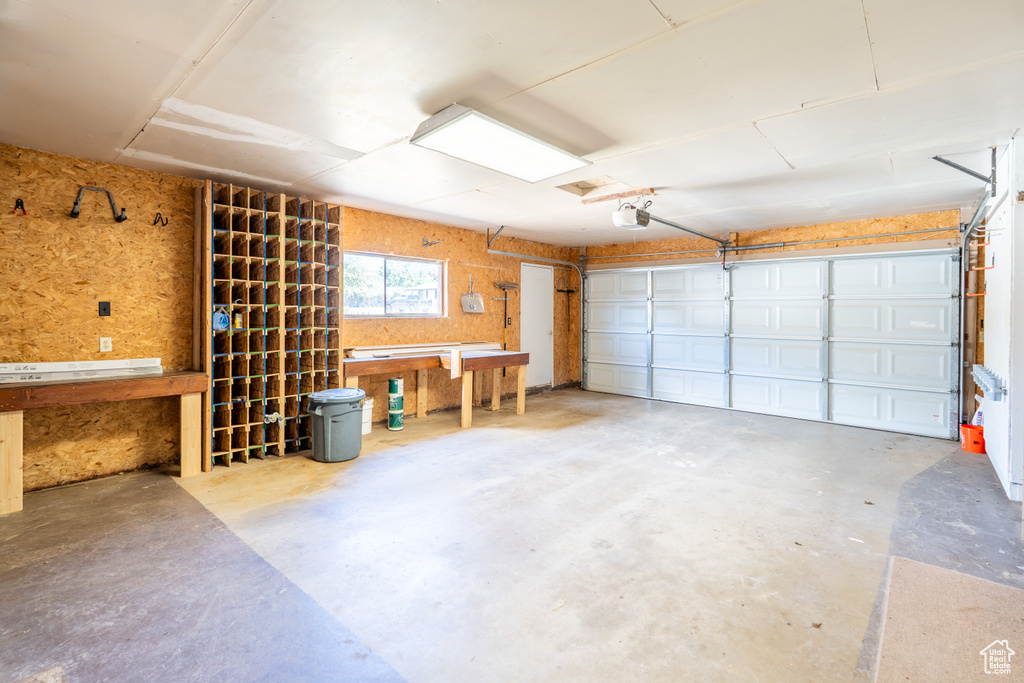 Garage featuring a workshop area and a garage door opener