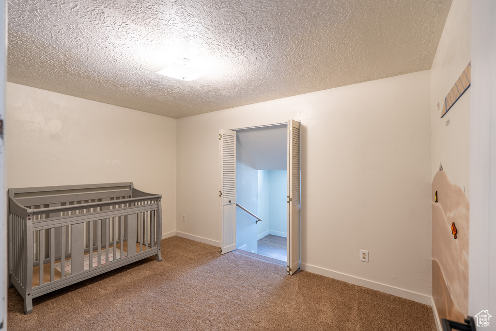 Unfurnished bedroom featuring carpet floors and a textured ceiling