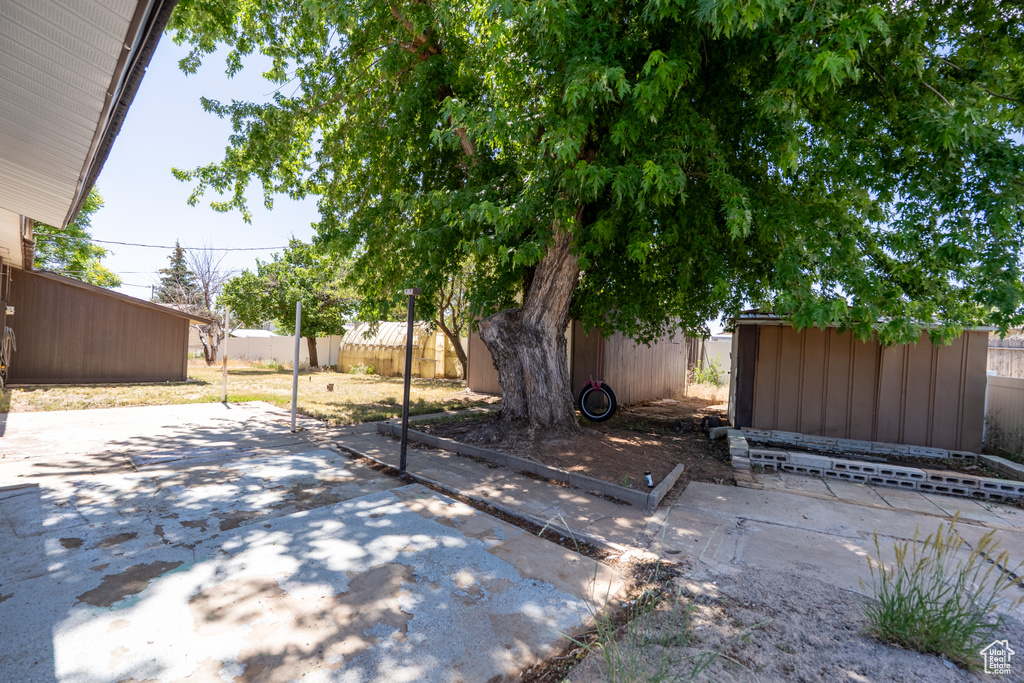 Fenced backyard with a storage shed and a patio