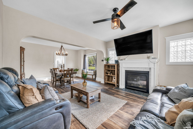 Living area featuring arched walkways, a ceiling fan, and wood finished floors
