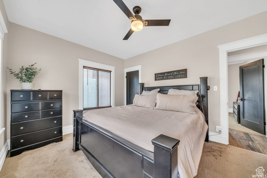Bedroom with ceiling fan and light carpet