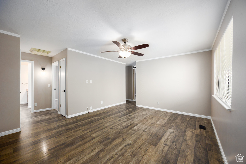 Spare room featuring a ceiling fan and dark wood-type flooring