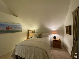 Bedroom featuring vaulted ceiling and carpet floors