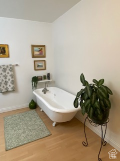Bathroom featuring a soaking tub and wood finished floors