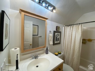 Bathroom featuring vanity, lofted ceiling, and shower / bathtub combination with curtain