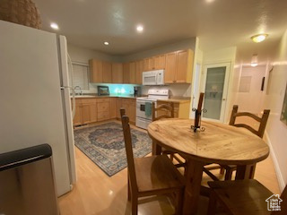 Kitchen with white appliances, recessed lighting, light wood-style floors, and light brown cabinetry