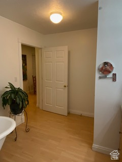 Hallway featuring light wood finished floors and baseboards