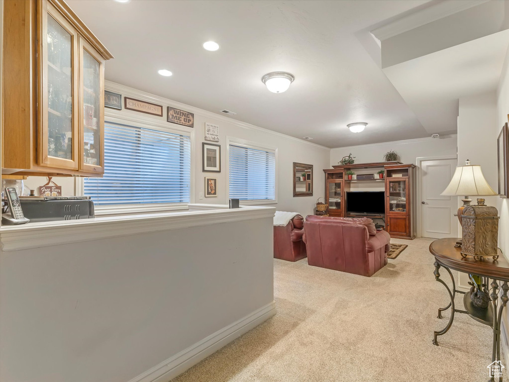 Living room with light colored carpet, ornamental molding, and recessed lighting