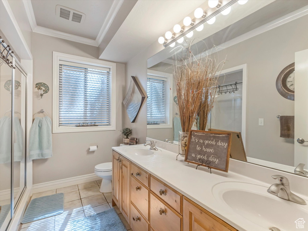 Full bath with double vanity, ornamental molding, tile patterned flooring, and a stall shower