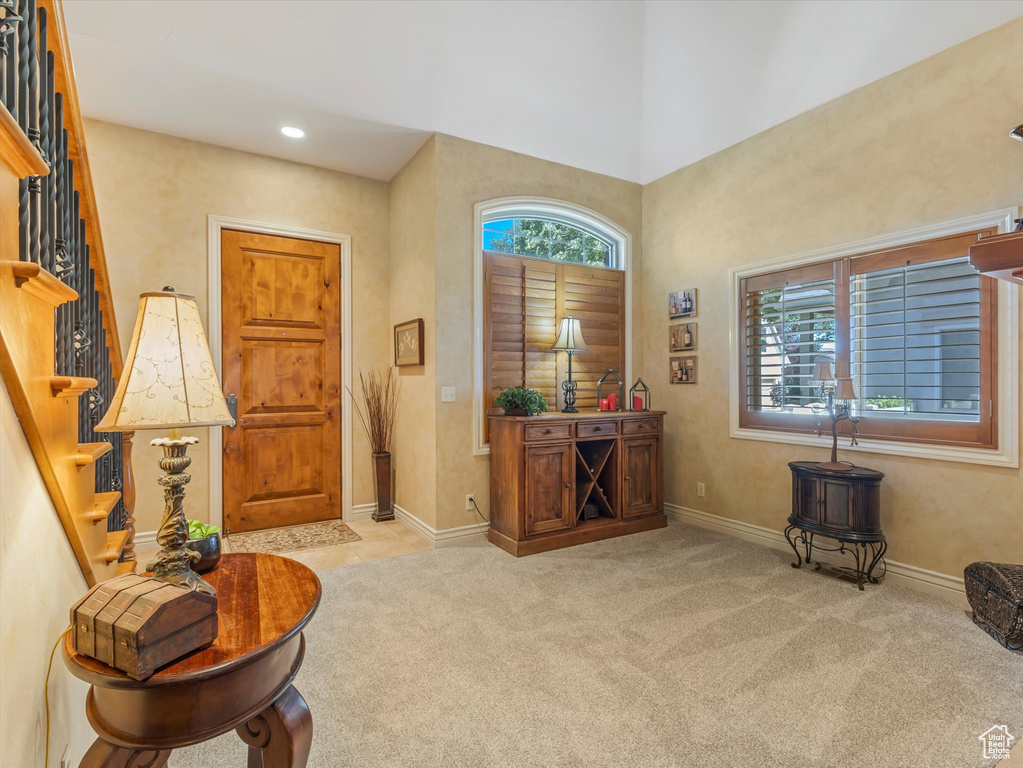 Carpeted entryway with stairway, a high ceiling, and recessed lighting